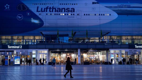 Passagiere gehen am Münchner Flughafen vor dem Ter