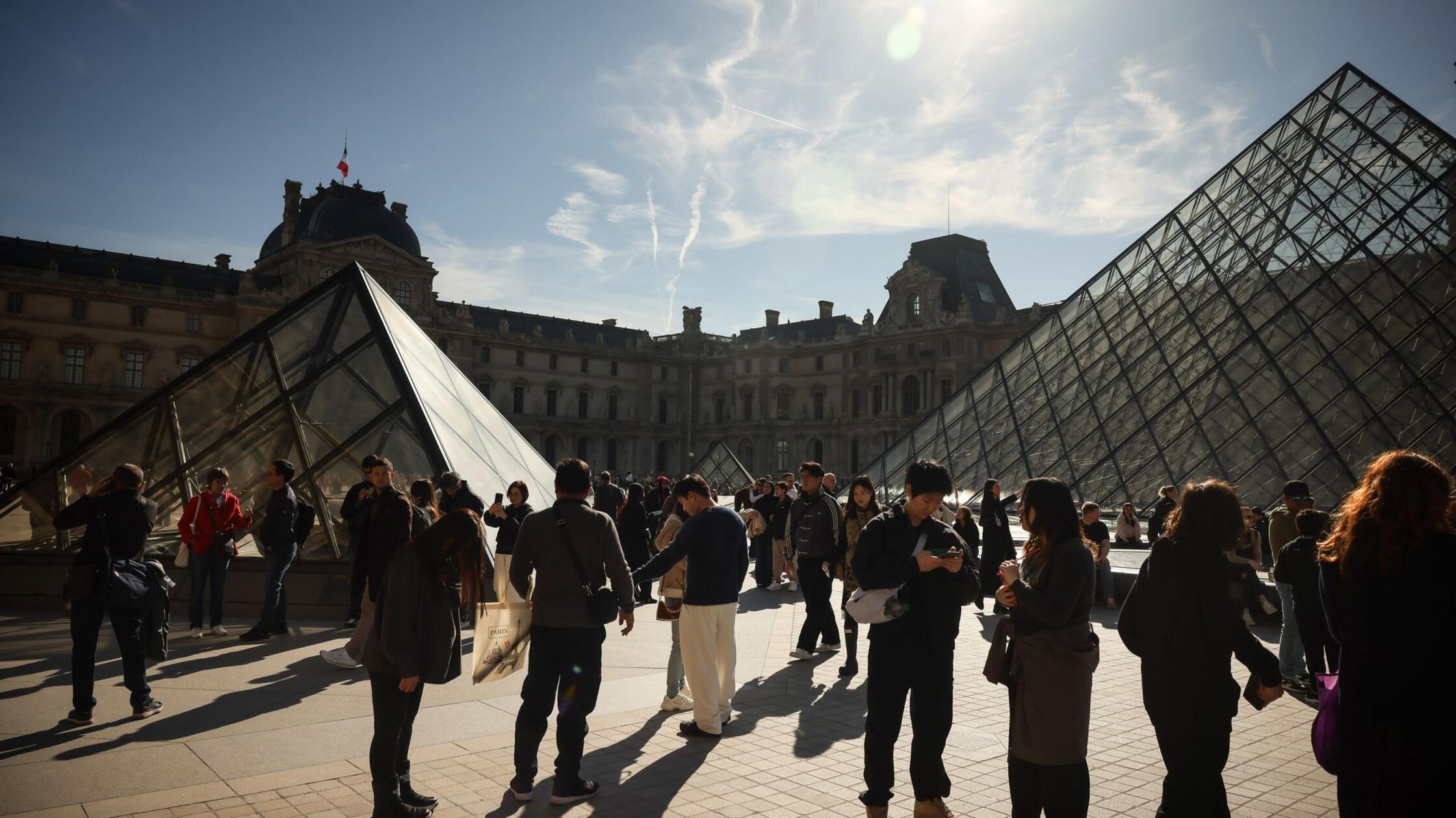 Menschen besichtigen den Innenhof des Louvre-Museu