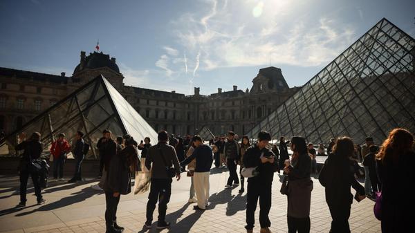 Menschen besichtigen den Innenhof des Louvre-Museu