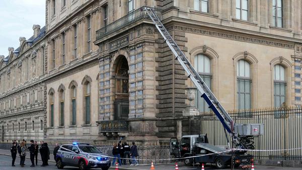 Polizisten stehen neben einem Möbelaufzug, mit dem