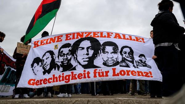 Demonstranten halten ein Transparent mit der Aufsc