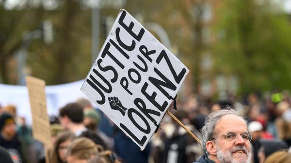 Ein Demonstrant hält ein Plakat mit der Aufschrift
