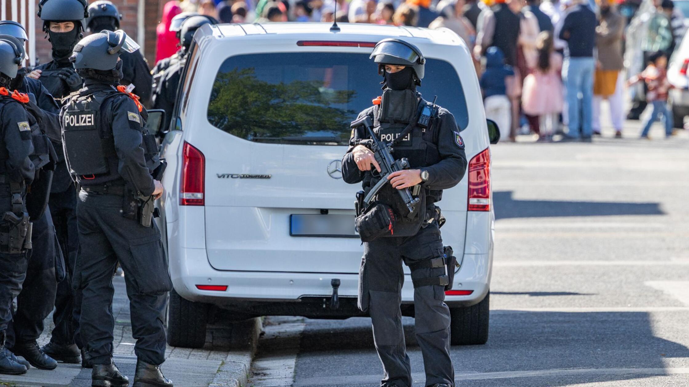 Vermummte Polizisten sind im Einsatz. Während eine