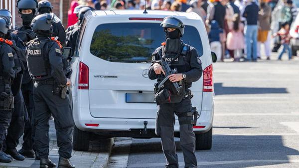 Vermummte Polizisten sind im Einsatz. Während eine