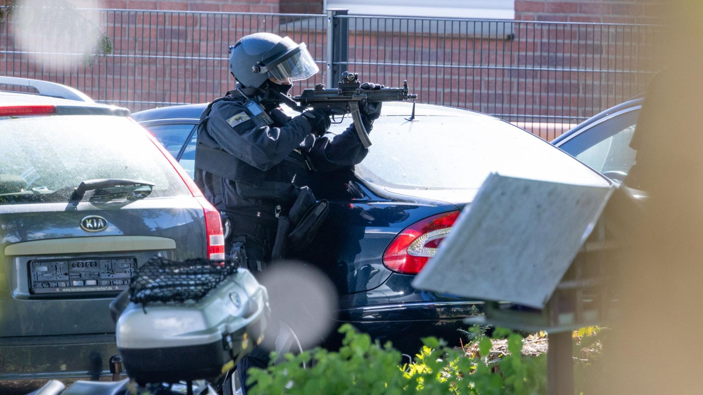 Ein vermummter Polizist ist im Einsatz und hält ei