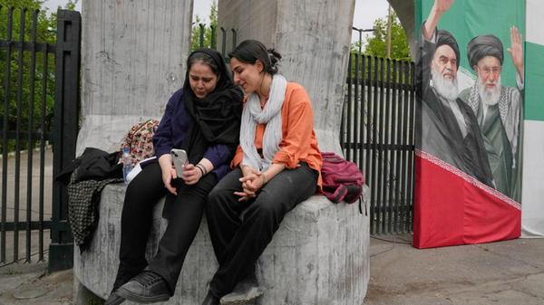 Frauen schauen gemeinsam auf ein Smartphone am Hau