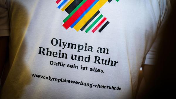 Ein Mann trägt ein T-Shirt mit der Rückenaufschrif