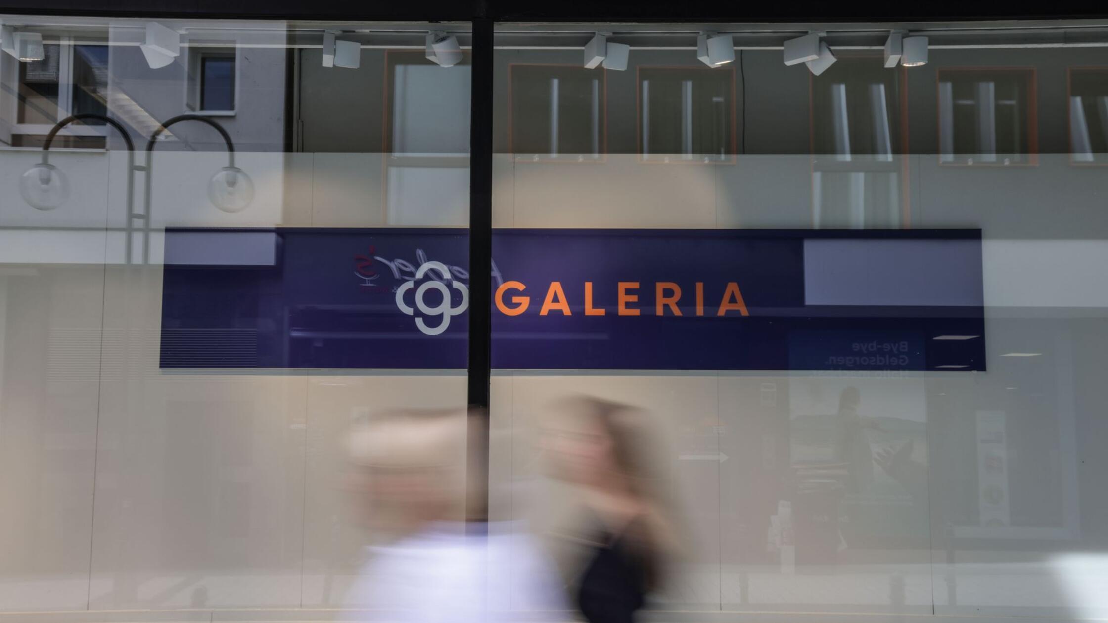 Frauen gehen am leeren Schaufenster einer Filiale 