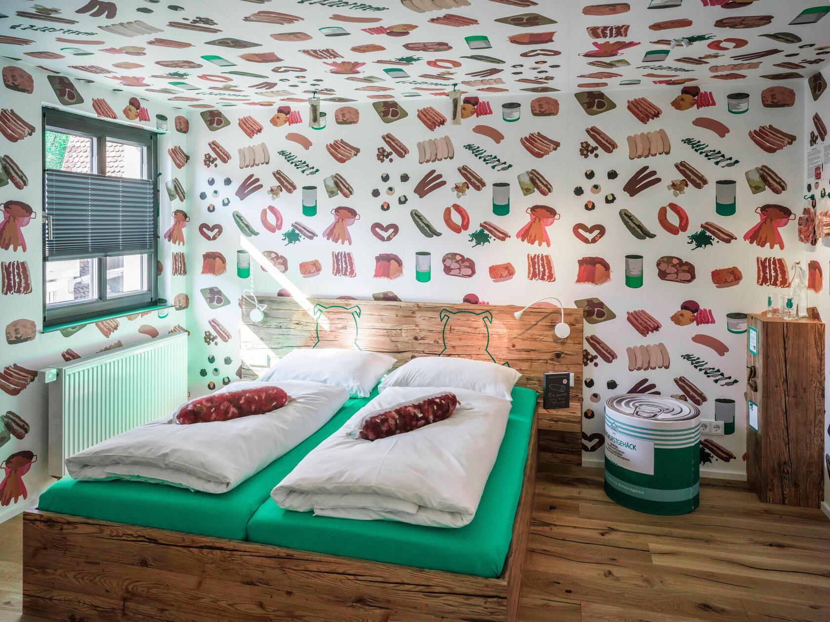 Ein Fleischermesser weist im Treppenhaus den Weg, Tapeten mit Wurstmuster und Kissen in Wurstform erwarten die Gäste: Das Bratwursthotel in Georgensgmünd dürfte für Vegetarierinnen und Vegetarier der reinste Alptraum sein. Erdacht hat das Konzept Metzgermeister Claus Böbel - und es funktioniert: Die sieben Bratwurst-Themenzimmer ziehen Gäste aus der ganzen Bundesrepublik in die fränkische Provinz, erzählt er.