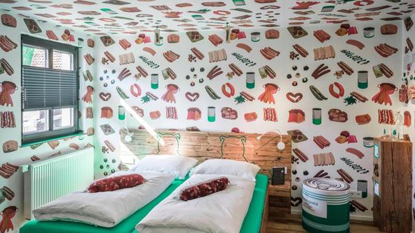 Ein Fleischermesser weist im Treppenhaus den Weg, Tapeten mit Wurstmuster und Kissen in Wurstform erwarten die Gäste: Das Bratwursthotel in Georgensgmünd dürfte für Vegetarierinnen und Vegetarier der reinste Alptraum sein. Erdacht hat das Konzept Metzgermeister Claus Böbel - und es funktioniert: Die sieben Bratwurst-Themenzimmer ziehen Gäste aus der ganzen Bundesrepublik in die fränkische Provinz, erzählt er.