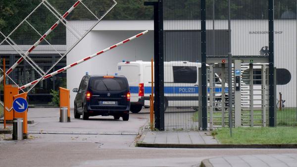 Einsatzfahrzeuge der Polizei fahren auf das Geländ