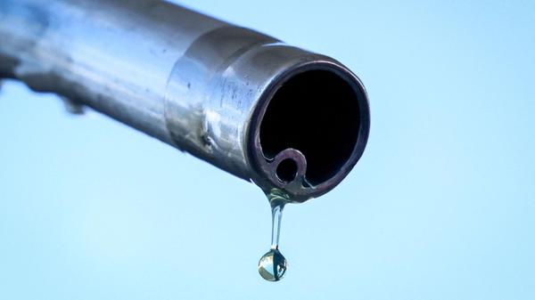 Ein Tropfen Benzin fällt aus der Zapfpistole einer