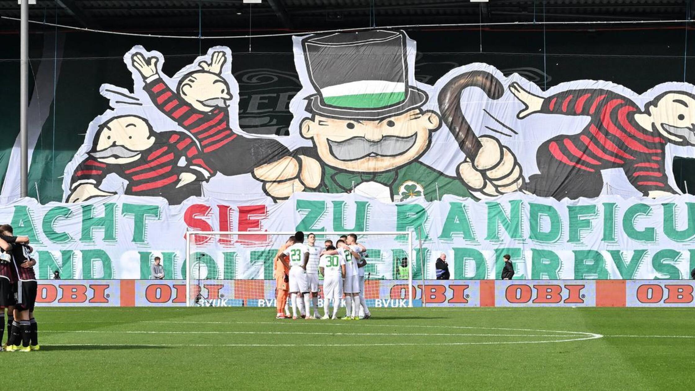 Anschließend formulierte ein überdimensionierter Monopoly-Mann eine klare Botschaft: "Macht sie zu Randfiguren und holt euch den Derbysieg!"