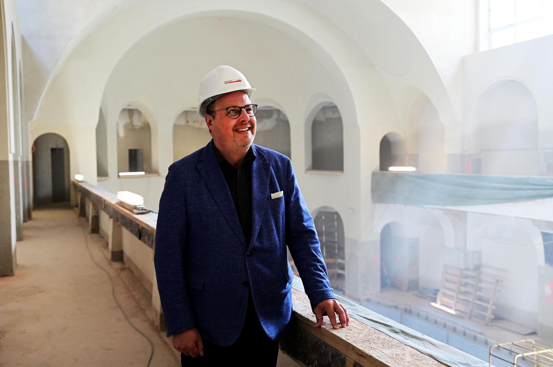Bei einem Rundgang durchs Volksbad informiert Christian Vogel, noch amtierender Werkleiter des städtischen Eigenbetriebs NürnbergBad und Bürgermeister, über den aktuellen Stand der Arbeiten. Es ist der Abschied von seinem "Herzensprojekt", wie der SPD-Politiker erklärt.