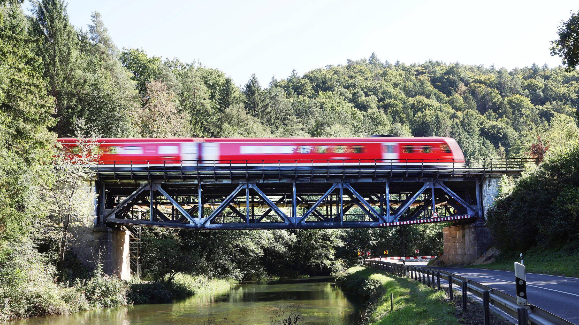 Regionalzug fährt über Eisenbahnbrücke der Staatst