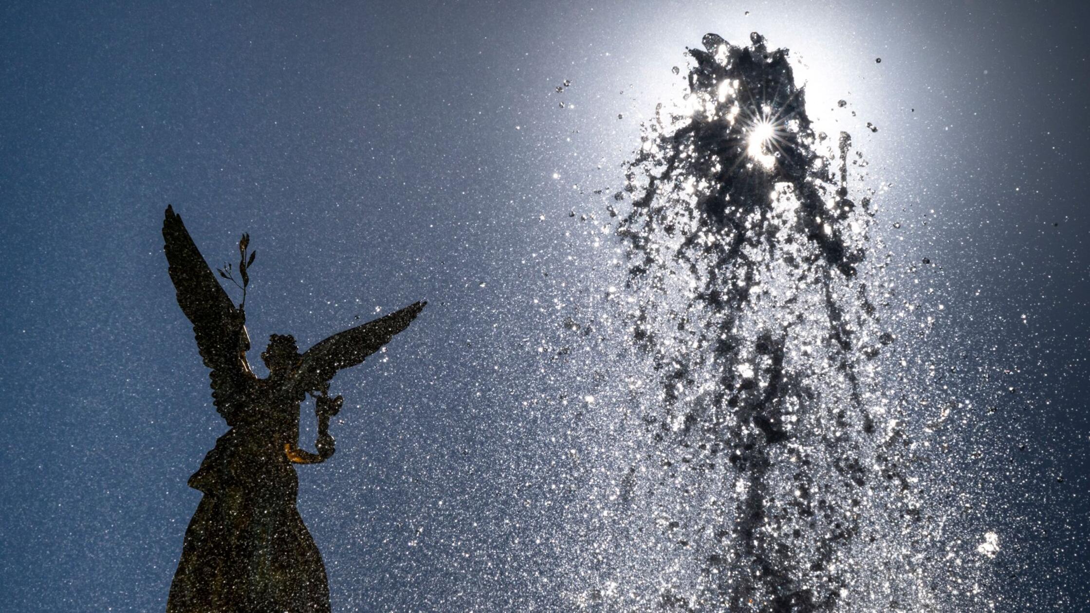 Eine Wasserfontäne schießt vor der vergoldeten Bro