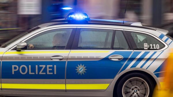 Ein Polizeiwagen fährt mit Blaulicht zu einem Eins