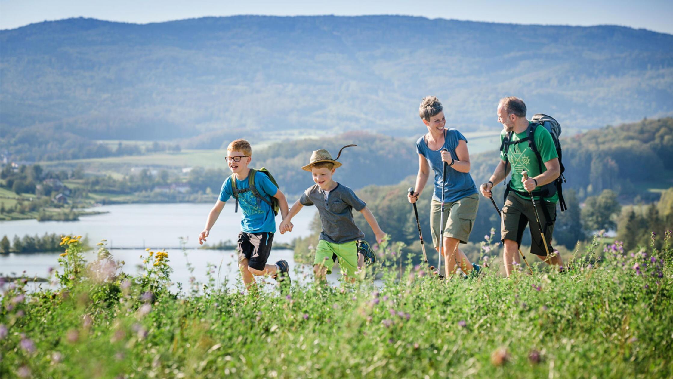 Familienwanderung durch blühende Wiesen im Naturpark Bayerischer Wald.