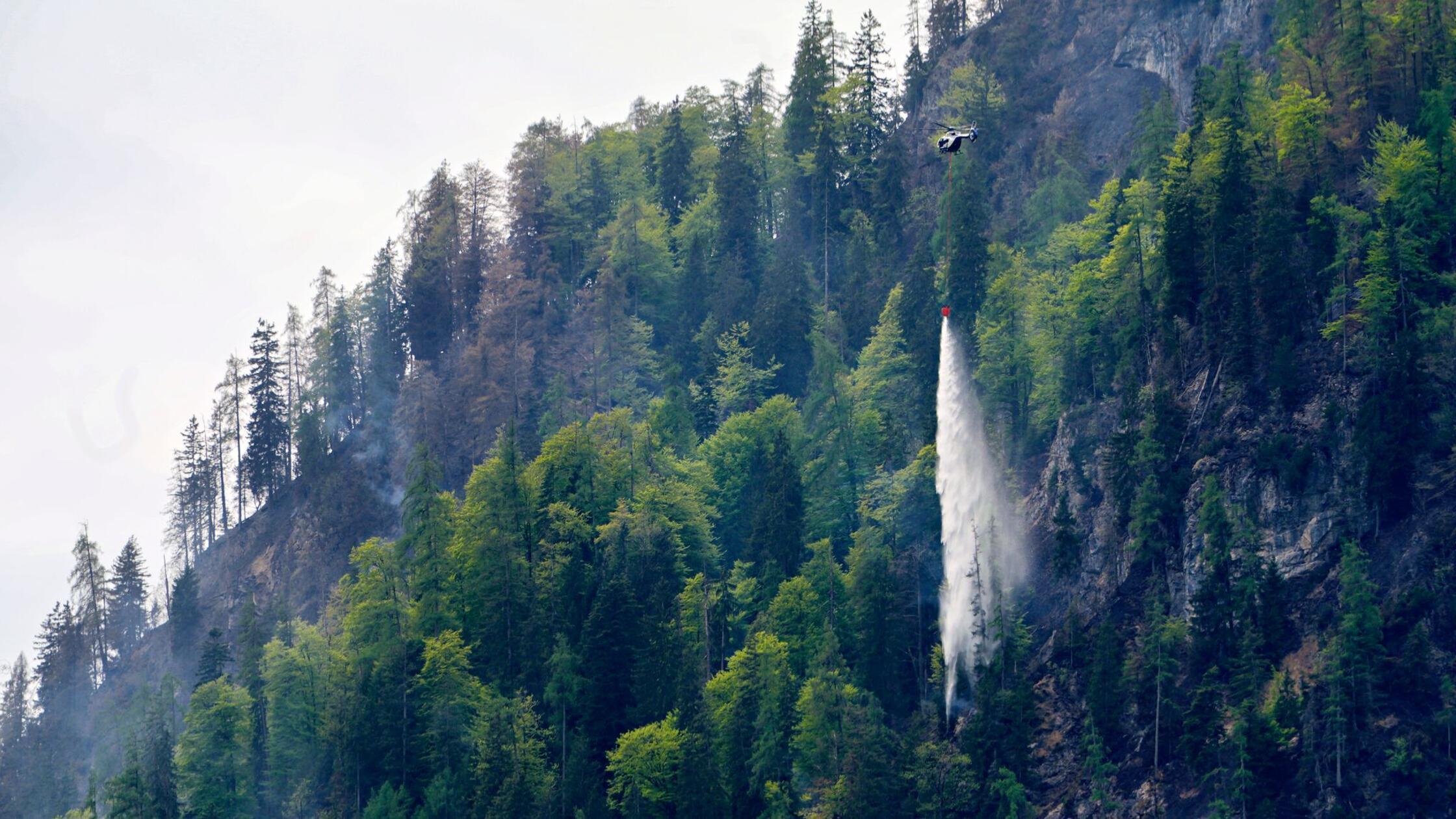 Hubschrauber lassen Löschwasser zur Bekämpfung des
