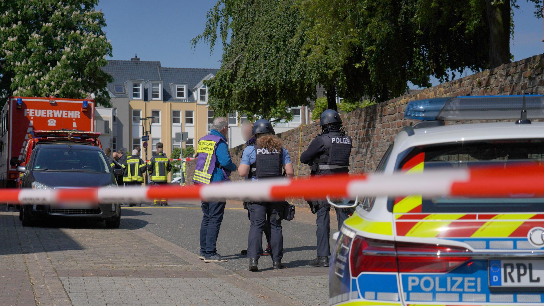 Polizisten und Polizeifahrzeuge stehen hinter Absp
