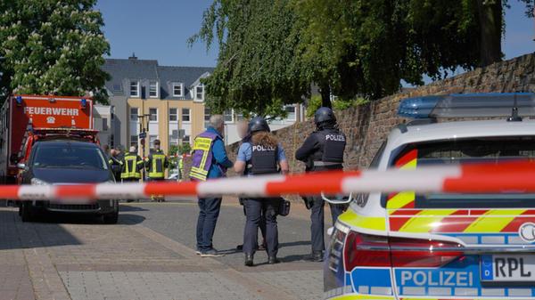 Polizisten und Polizeifahrzeuge stehen hinter Absp
