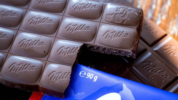 Milka-Schokoladentafeln liegen auf einem Tisch. (z