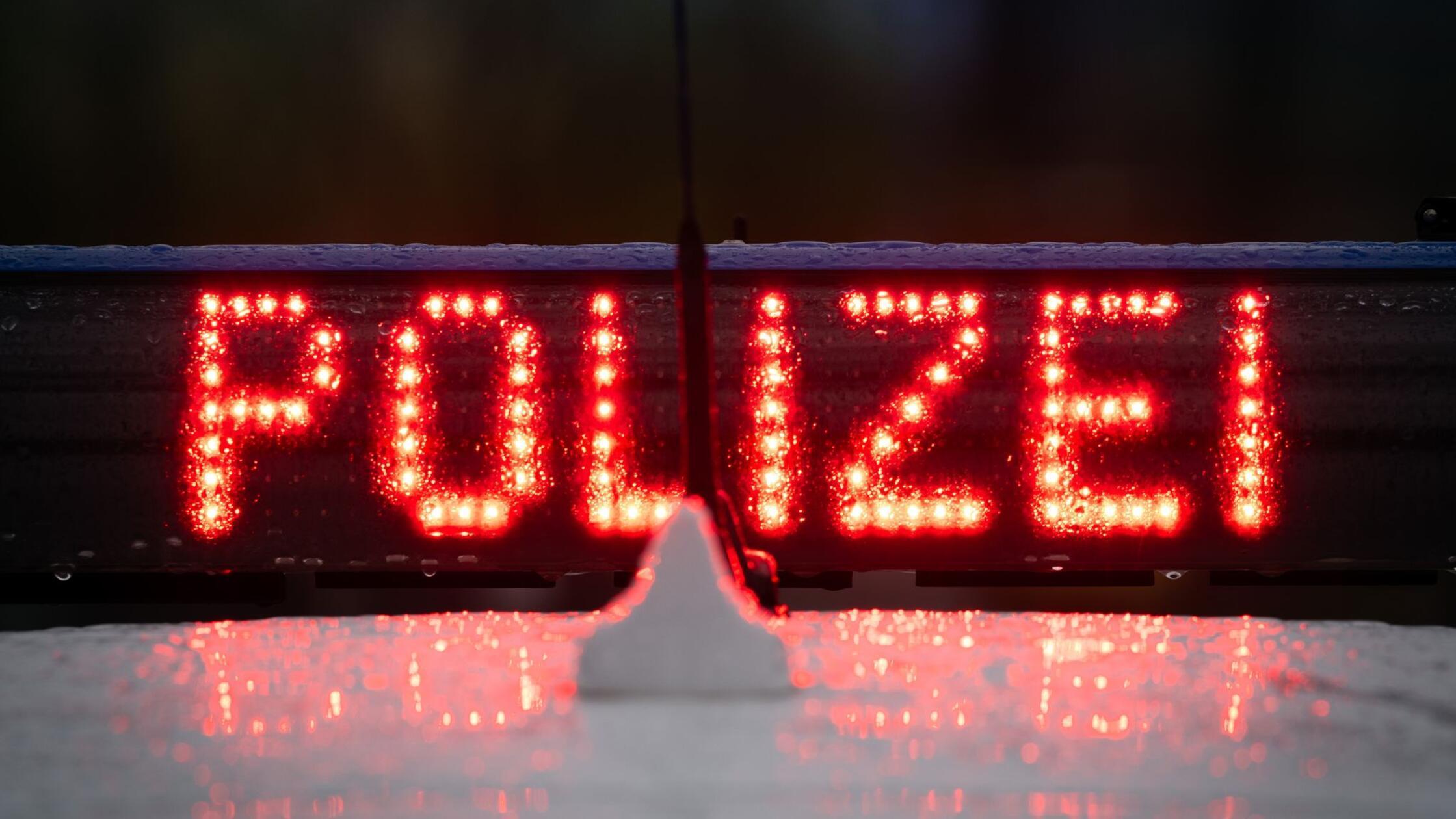 Der Schriftzug „Polizei“ auf einem Polizeiwagen. (