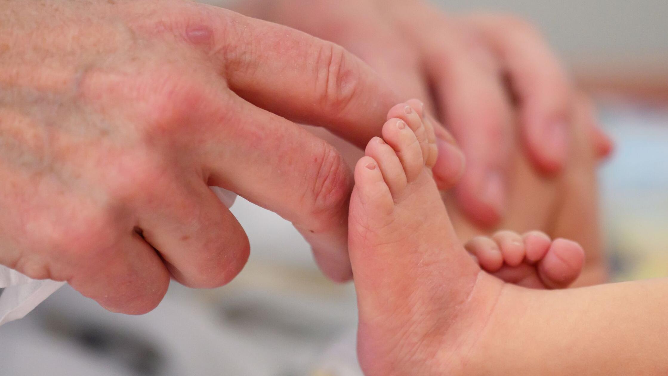 Eine Kinderkrankenschwester berührt die Füße eines