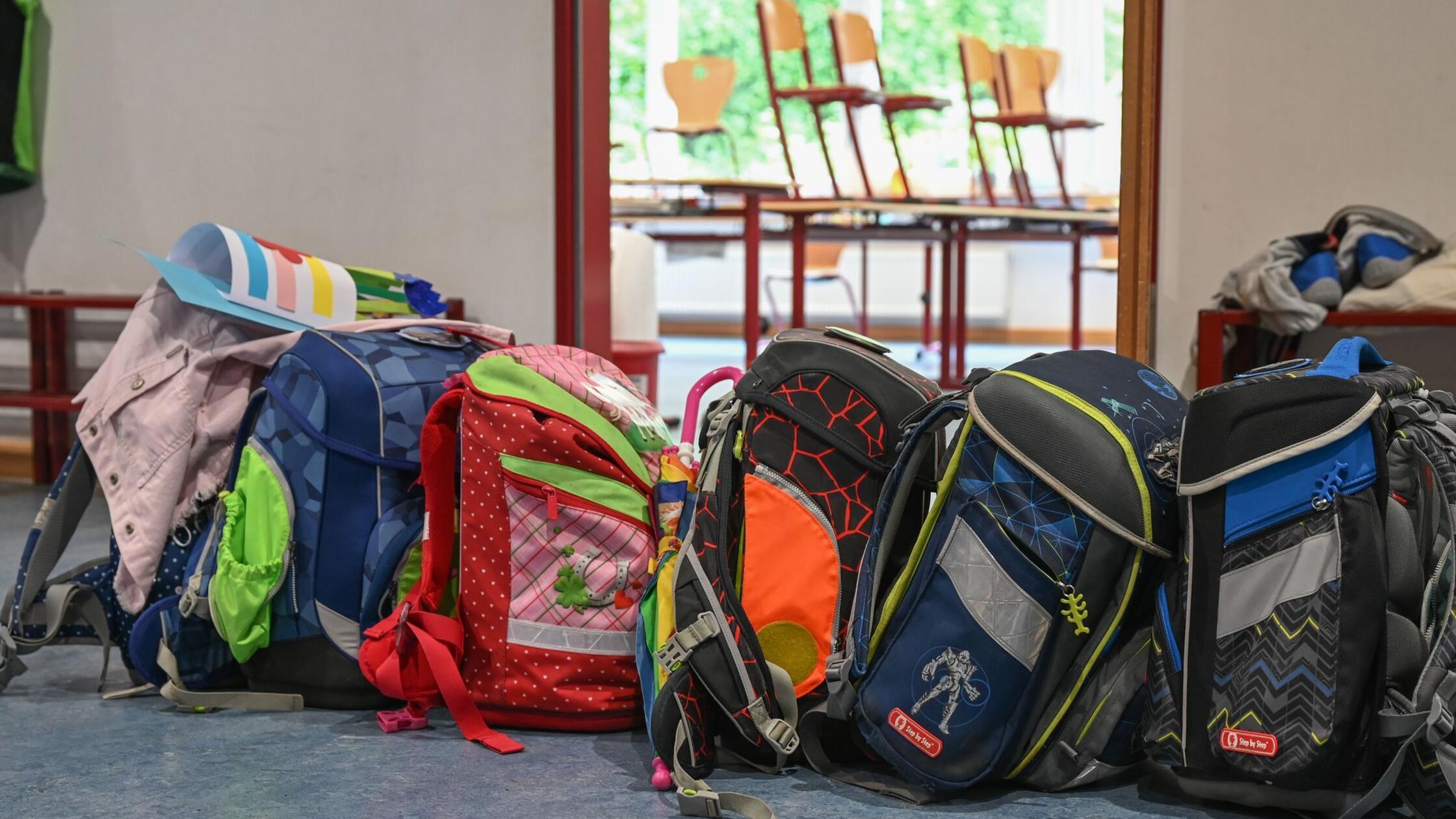 Schulranzen stehen vor einem Klassenzimmer. (zu dp