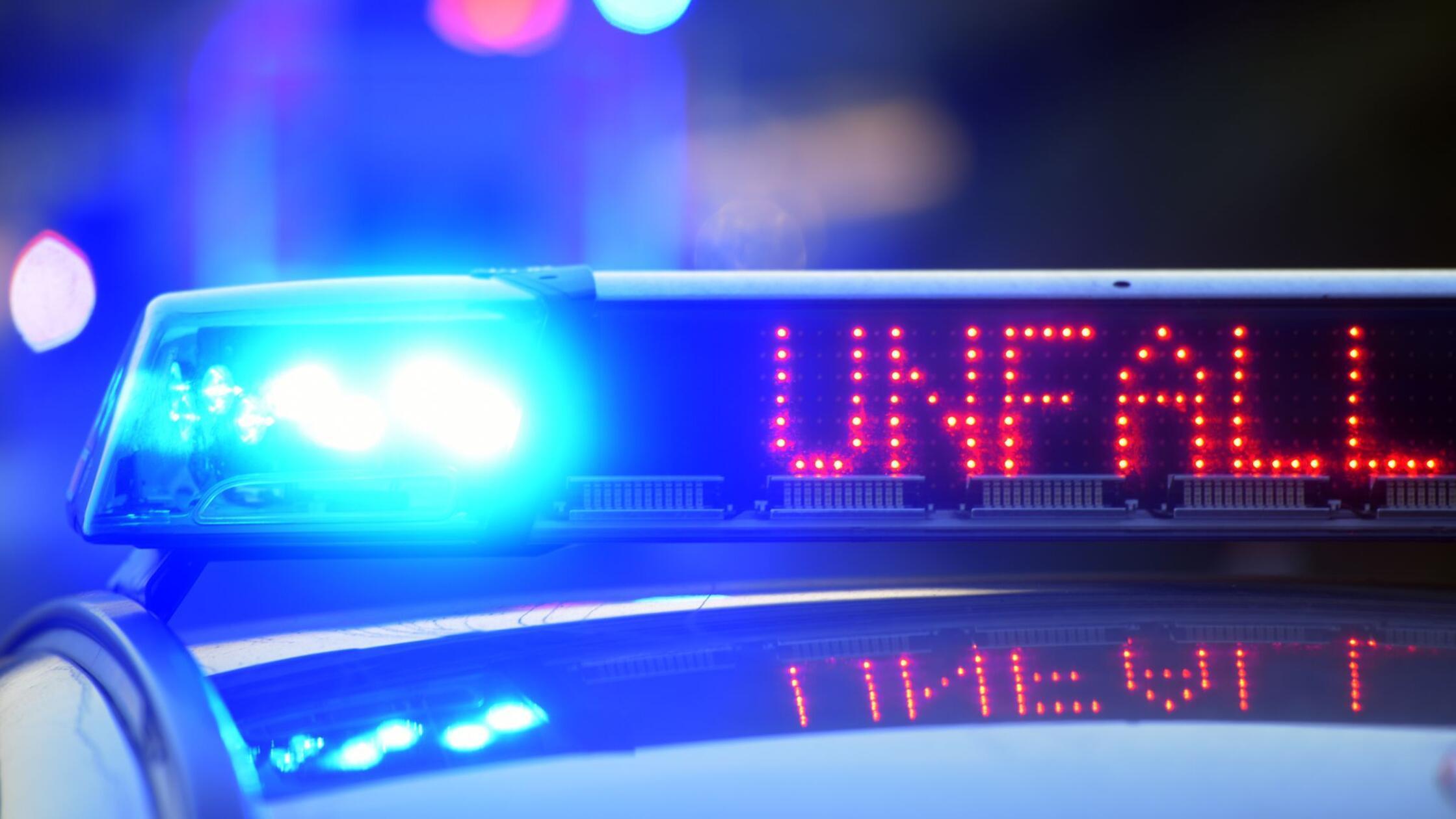 Auf einem Polizeifahrzeug warnt eine Leuchtschrift