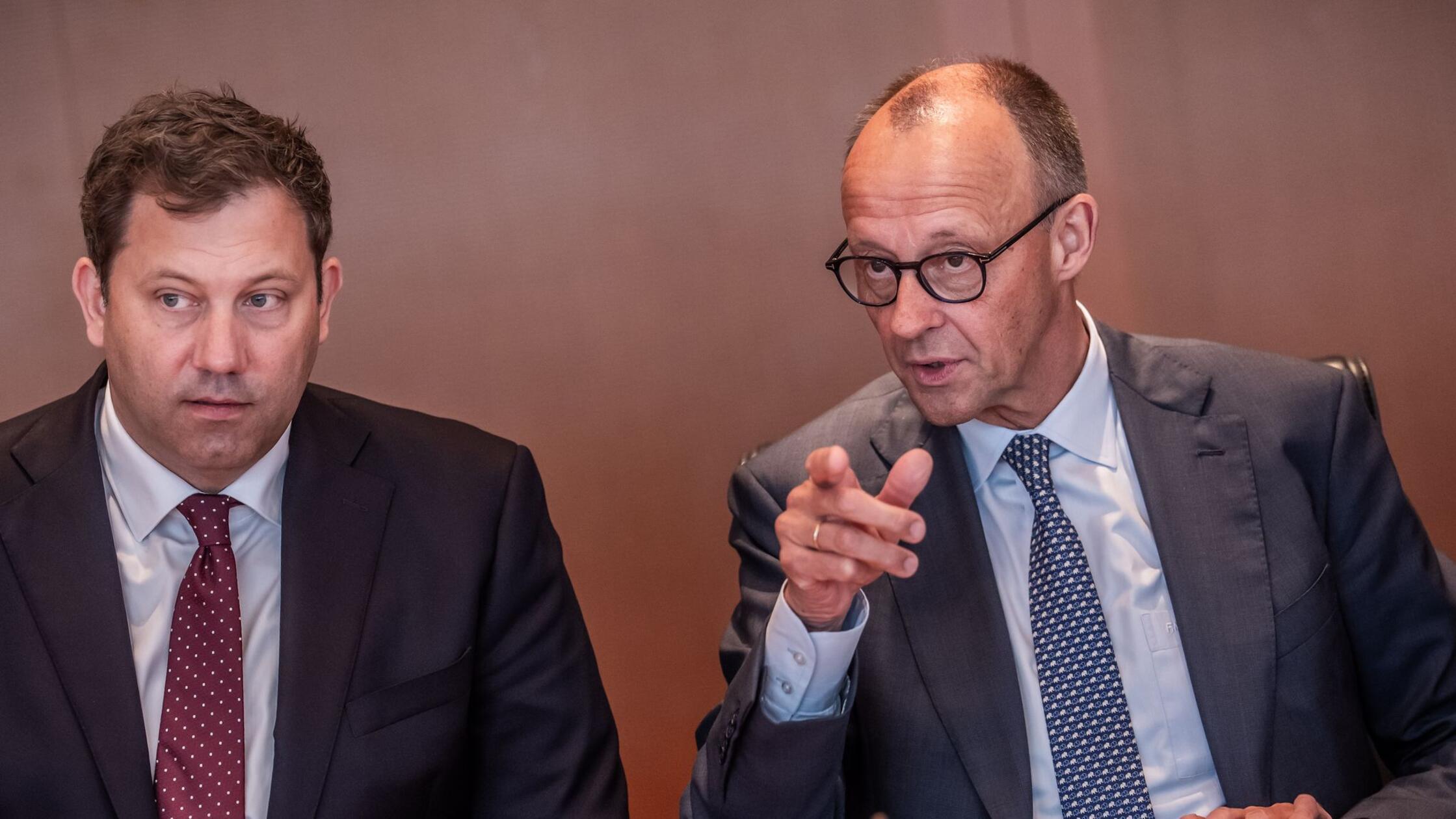 Bundeskanzler Friedrich Merz (r, CDU) spricht mit 
