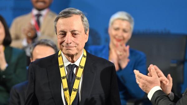 Der frühere EZB Präsident Mario Draghi steht mit d