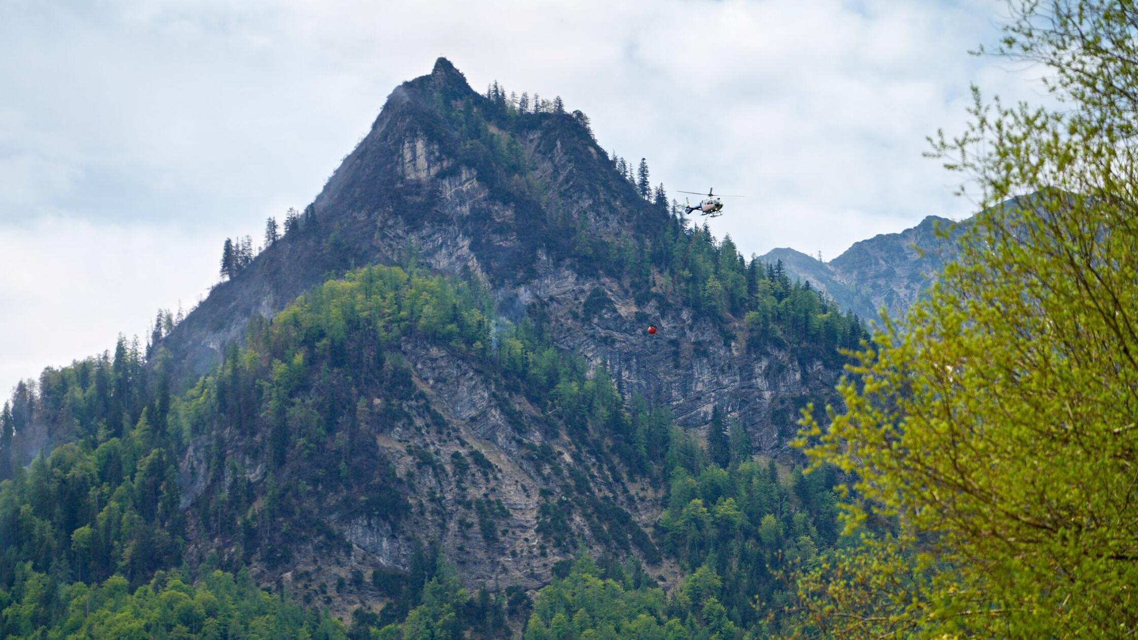 Hubschrauber lassen Löschwasser zur Bekämpfung des