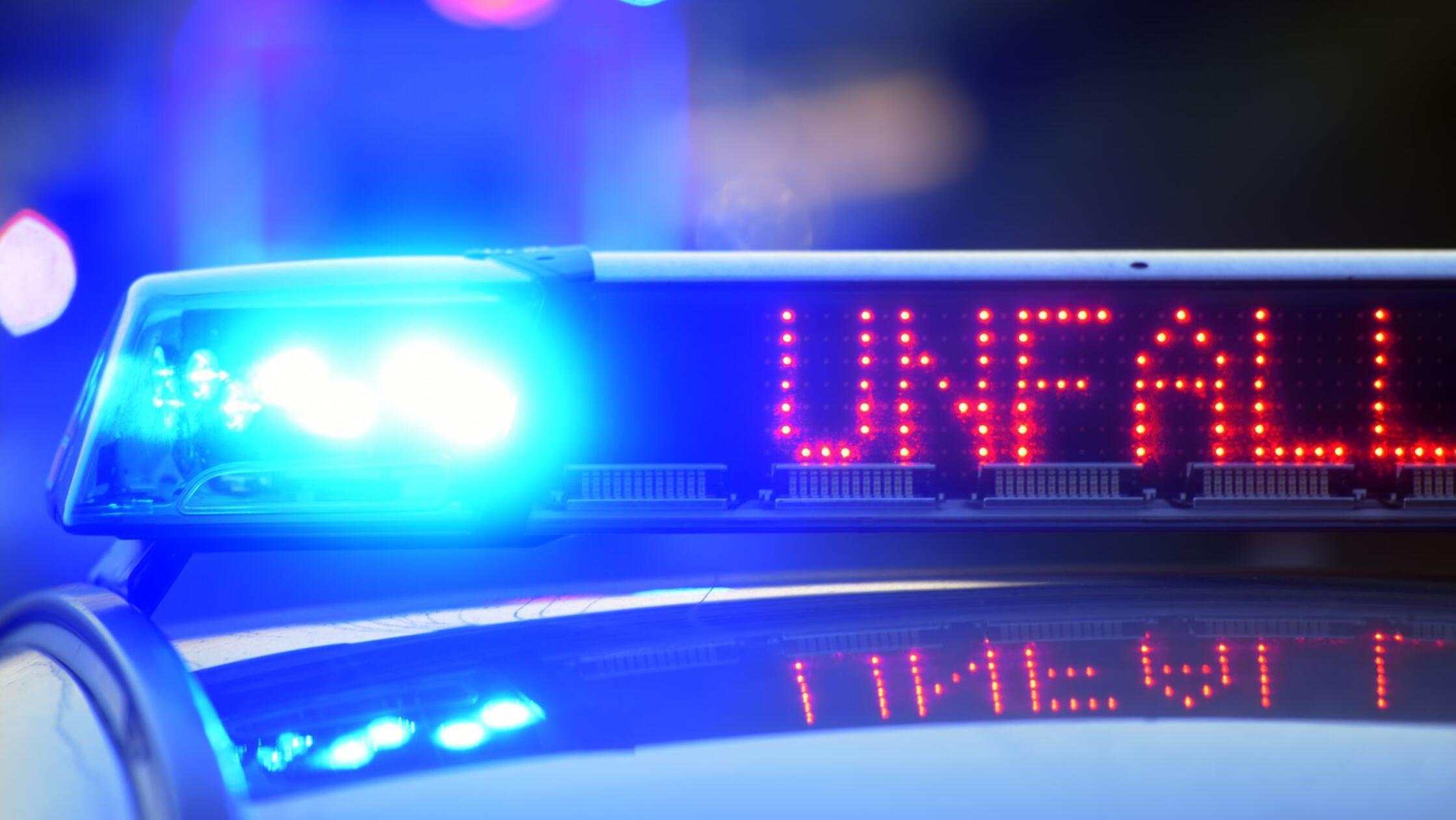Auf einem Polizeifahrzeug warnt eine Leuchtschrift
