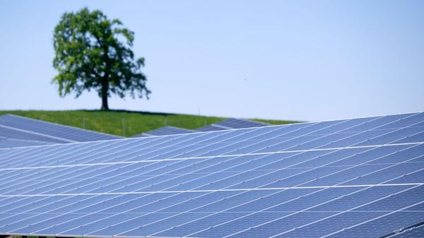 Die Sonne scheint auf einen Solarpark in der Nähe