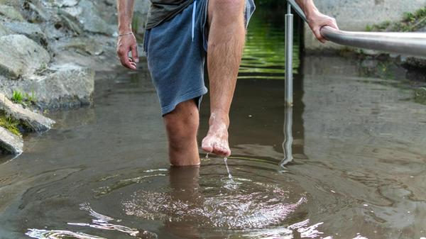 Wassertreten im Kneippbecken: Mit erhobenem Bein g