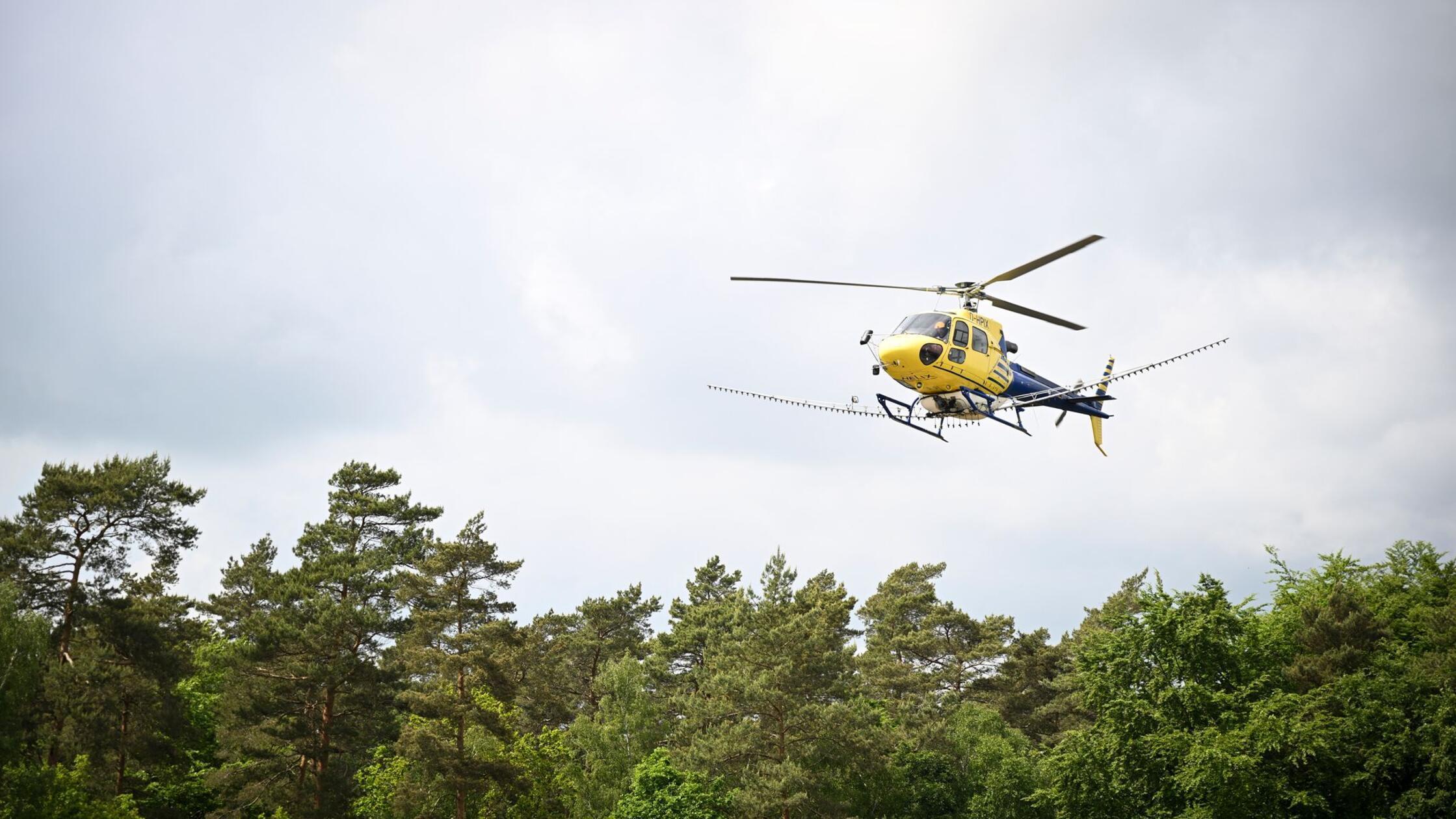 Ein mit Sprüharmen ausgestatteter Hubschrauber ist