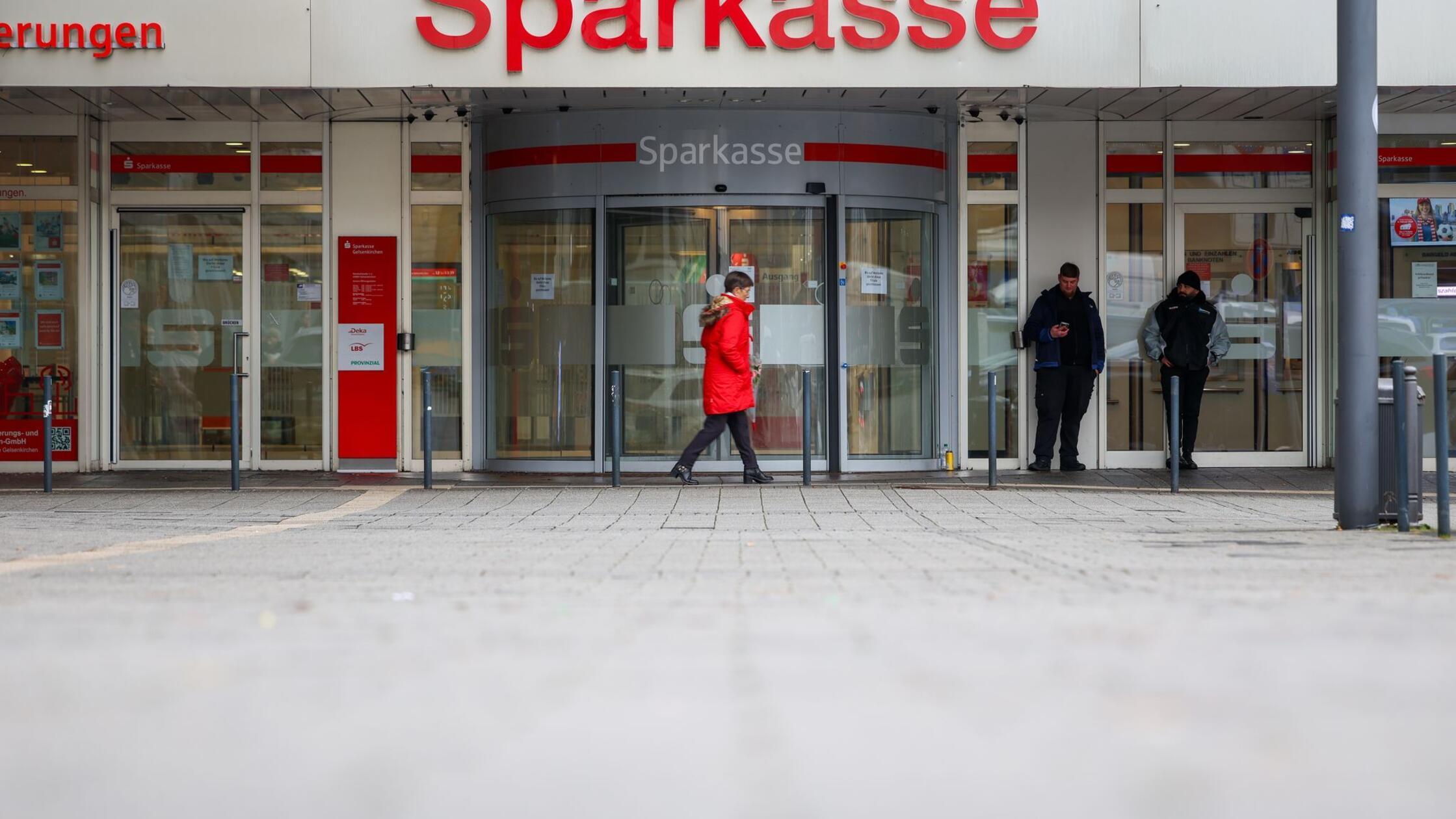 Security-Mitarbeiter stehen vor der Sparkasse Gels