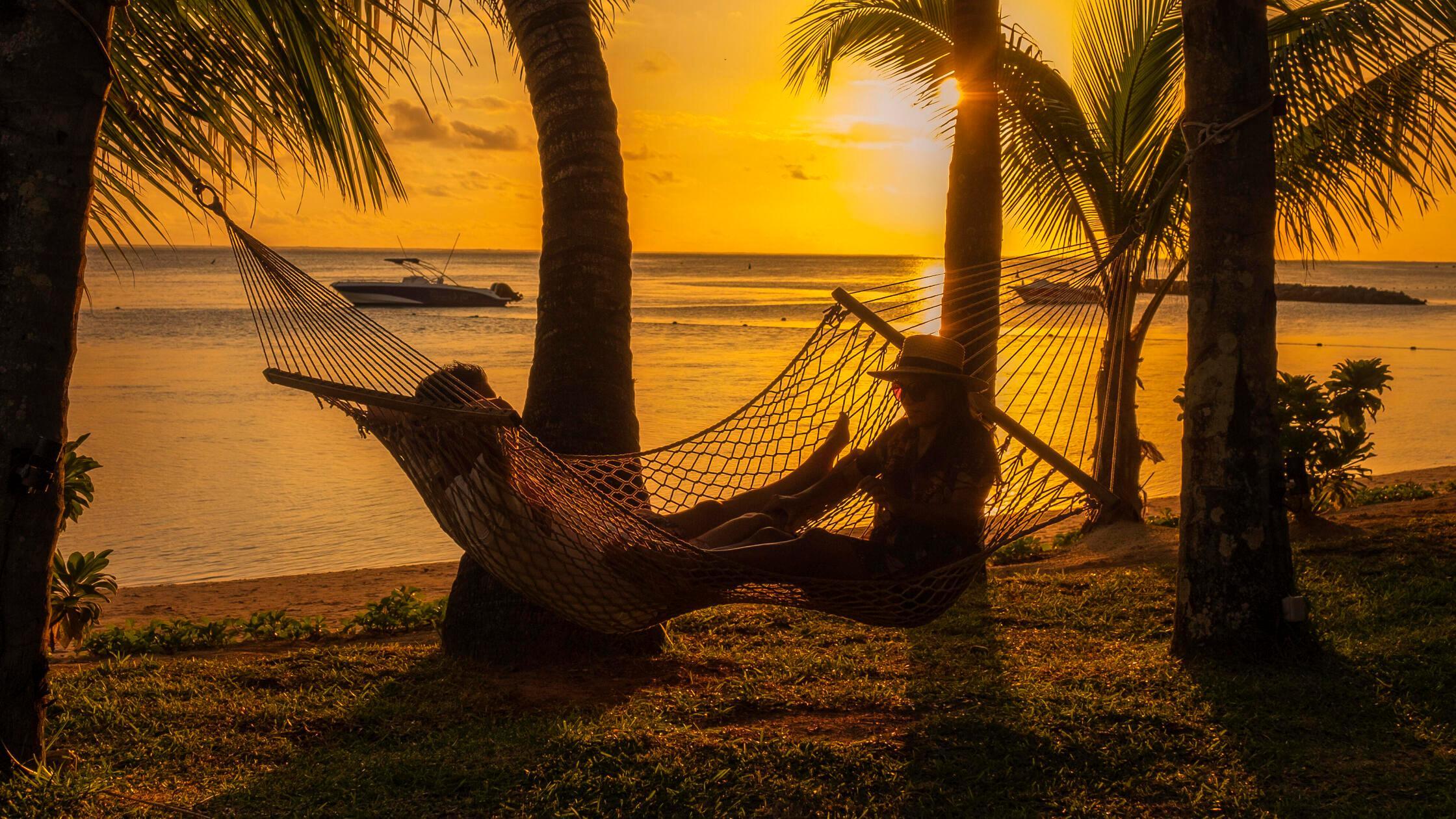 couple men and woman watching sunset on a tropical