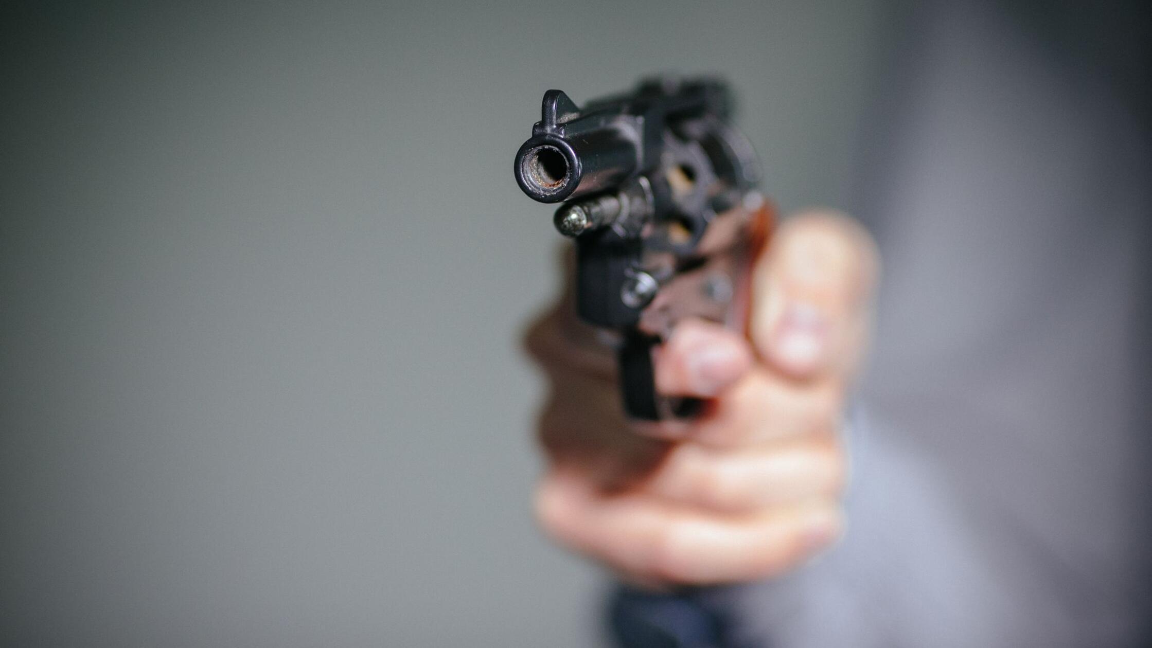 Ein Mensch hält einen Schreckschuss-Revolver in de