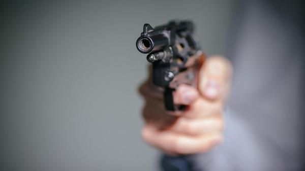 Ein Mensch hält einen Schreckschuss-Revolver in de