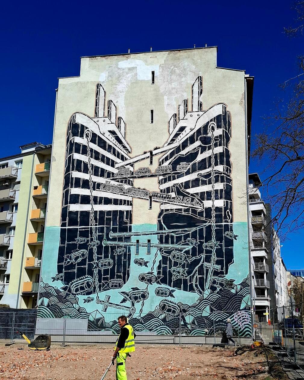 Das Bild zeigt ein großformatiges Wandgemälde (Mural) des polnischen Künstlers Mariusz Waras, bekannt als M-City, in der Hafenstadt Gdynia. Das Selbstverständnis der Stadt ist eng verknüpft mit der Emigration von Millionen von Polen in die ganze Welt. Weil die einzige Hafenstadt Danzig eine freie Handelsstadt war, wollte Polen einen eigenen Hafen bauen. So entstand aus dem Fischerdorf Gdynia vor 100 Jahren die Hafenstadt Gdynia mit heute 250.000 Einwohnern.