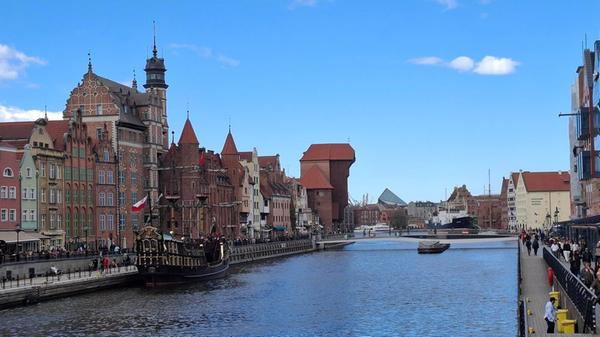 Danzig (polnisch: Gdańsk) ist eine über 1000 Jahre alte Hansestadt an der polnischen Ostseeküste und bildet zusammen mit Sopot und Gdynia die Metropolregion „Dreistadt“ (Trójmiasto). Sie ist weltberühmt für ihre rekonstruierte Rechtstadt, ihre Rolle als Schauplatz des Beginns des Zweiten Weltkriegs sowie als Wiege der Gewerkschaftsbewegung Solidarność, die maßgeblich zum Fall des Kommunismus in Europa beitrug. Hier die Häuserzeile mit dem Krantor im Hintergrund entlang der Mottlau. Im Vordergrund ein Pratenschiff, auf dem Touristen auf dem Fluss bis zur Ostsee fahren können und einiges über die Stadt erfahren.