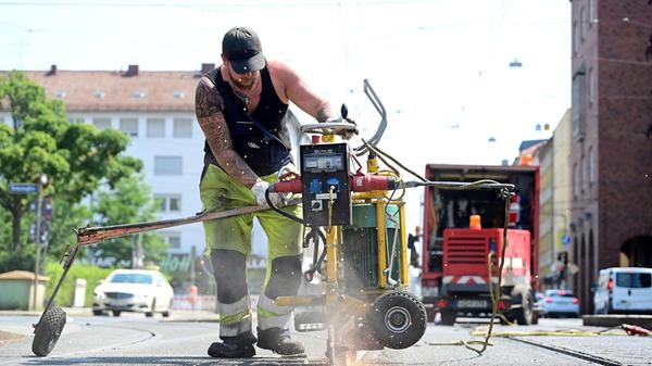 Mitarbeiter der VAG befreien in der Südstadt die Schienen von dem Bitumen. Hier in der Landgrabenstraße.