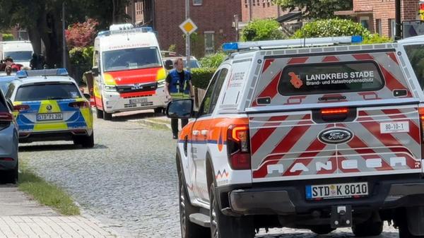 Einsatzkräfte stehen auf einer Straße in Stade. In