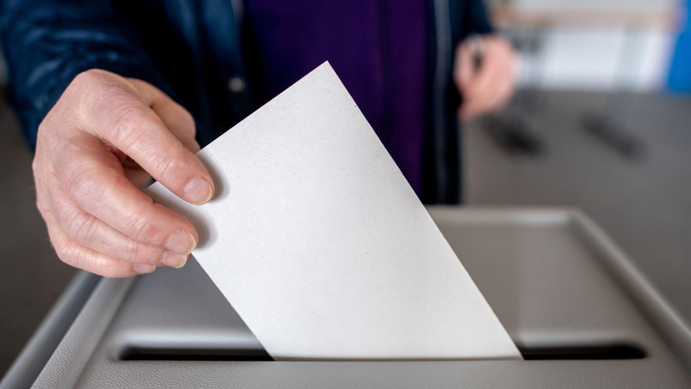 Ein Wähler wirft in einem Wahllokal seinen Stimmze