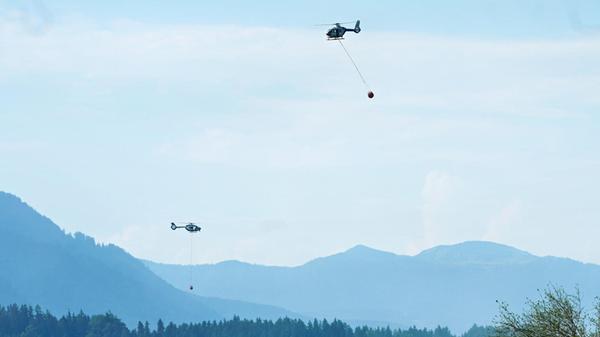 Ein Hubschrauber mit Löschwasser aus dem Chiemsee