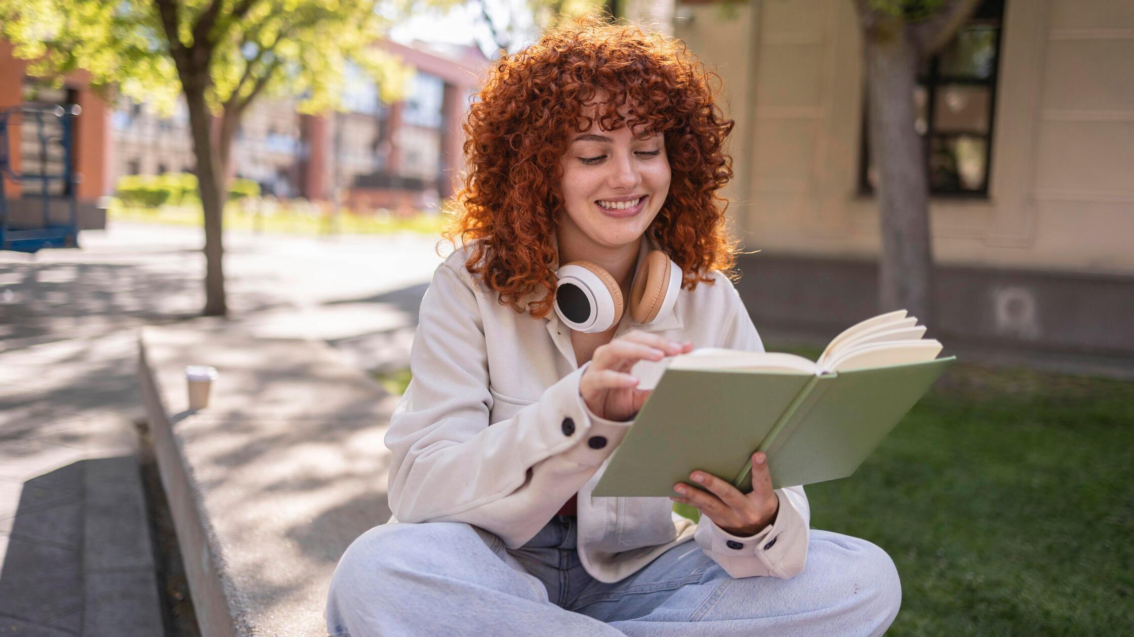 Student reading a book on a university campus in M