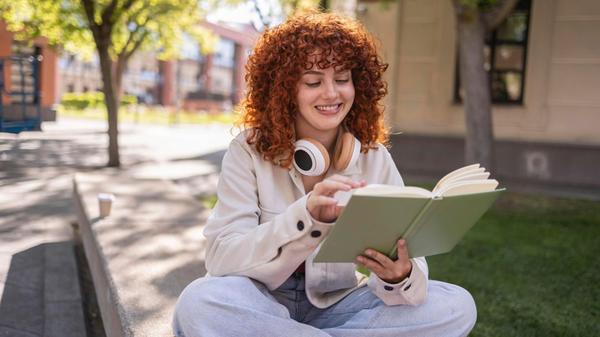 Student reading a book on a university campus in M