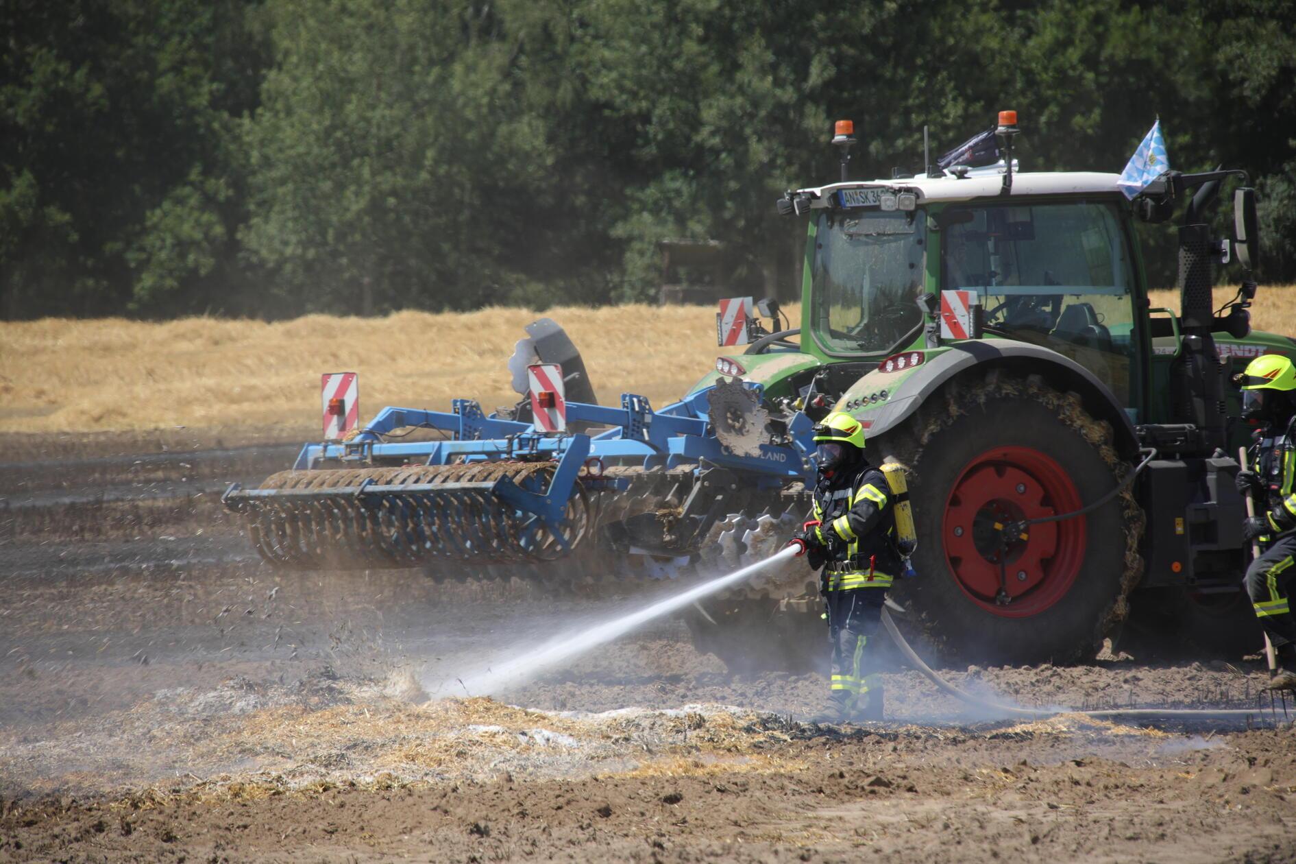 Um dem Feuer den Weg abzuschneiden, gruben Landwirte mithilfe ihrer Landmaschinen zudem den Boden rund um den brennenden Feldabschnitt um.